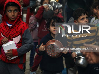Palestinian children wait to get soup offered for free during the Muslim fasting month of Ramadan, in Gaza City on April 13, 2021.
 (