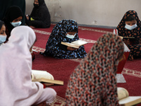 Palestinian girls, mask-clad due to the COVID-19 coronavirus pandemic attend a Koran memorisation lesson during the holy month of Ramadan, i...