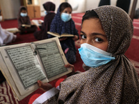 Palestinian girls, mask-clad due to the COVID-19 coronavirus pandemic attend a Koran memorisation lesson during the holy month of Ramadan, i...