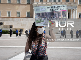 Student wearing protective face mask holds a banner during a protest against the government-promoted plan to create dedicated university pol...