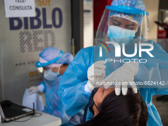 A nurce takes a free PCR test to a patient at the Transmilenio Bus Hub Portal el Dorado on April 15, 2021, in Bogota, Colombia amid a new th...