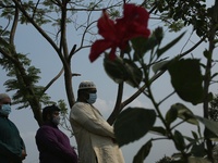Relatives pray at the burial of their families at the Covid-19 special public cemetery in Dhaka, Bangladesh on April 16, 2021. (