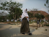 A women walks though Covid-19 special public cemetery as she come to pray for her death relative in Dhaka, Bangladesh on April 16, 2021. (