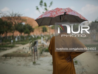 A man stands near his relative's grave at the Covid-19 special public cemetery in Dhaka, Bangladesh on April 16, 2021. (