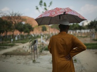 A man stands near his relative's grave at the Covid-19 special public cemetery in Dhaka, Bangladesh on April 16, 2021. (