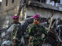 An Indonesian military standing on debris of air force-owned aircraft that crashed in Medan, North Sumatra, Indonesia on June 30, 2015. The...