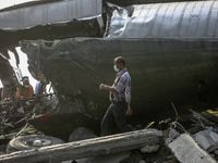 Rescue team walk on the debris of air force-owned aircraft that crashed in Medan, North Sumatra, Indonesia on June 30, 2015. The Hercules C-...