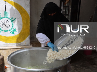 Syrian woman prepare meals for distribution to the poor in Idlib, Syria, on April 18, 2021. (