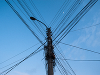 Street lamp in Yambol, Bulgaria, is overloaded with power wires and internet, cable tv and telephone cables, on April 20th 2021. Althought m...
