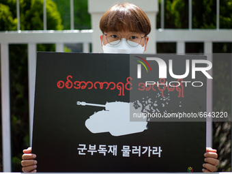 A South Koean activist holds a banner that says, Stop The Military Dictatorship, during a press conference outside of Indonesian Embassy in...
