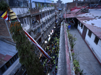 Nepalese Devotees pulling the chariot of Seto Machindranth along with the primary precaution wearing face mask and gloves during celebration...