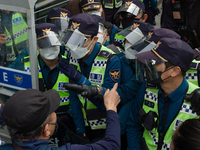 Protesters conflict with police officers during a protest against the Japanese government's decision to release radioactive water from Fukus...