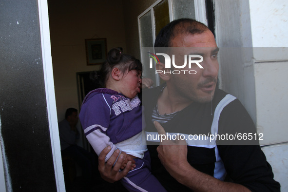 Ramallah, West Bank, Palestinian Territories, March 28, 2014: A Palestinian Man with his daughter crying because of the tear gas thrown by...