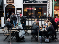 People drink and eat in outdoor street dining areas, as lockdown restrictions are eased amidst the spread of the coronavirus disease (COVID-...