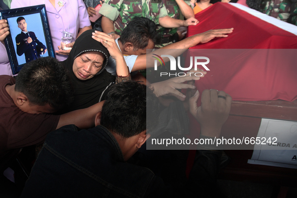 Family grief crying beside the body's coffin corpse military personnel, one of the victims of the collapse of the C-130 military aircraft du...