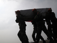 Relatives lifting body coffin corpse military personnel, one of the victims of the collapse of the C-130 military aircraft during the sendof...