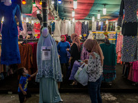 A woman shops for new clothes at a Ramadan bazaar during the holy month of Ramadan in Kuala Lumpur, on April 25, 2021. During the holy month...