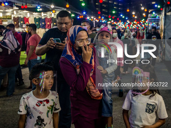 People wearing protective masks shop at a Ramadan bazaar during the holy month of Ramadan in Kuala Lumpur, on April 25, 2021. During the hol...