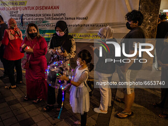 People queue as they wait to entering a Ramadan bazaar during the holy month of Ramadan in Kuala Lumpur, on April 25, 2021. During the holy...