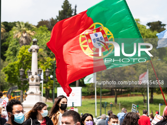  People march holding up red carnations and the Portuguese flag to commemorate the anniversary of the Portugal's revolution, in Lisbon, Port...
