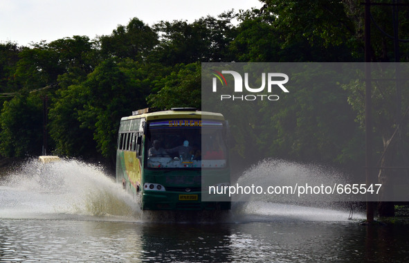 A passenger bus moves on a flooded  pathway following heavy rain in Allahabad on July,1,2015. 