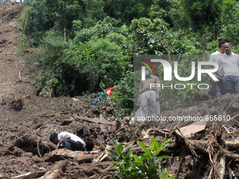 Rescue workers search for survivors amongst the rubble after a landslide at Darjeeling district in West Bengal, India, July 1, 2015. At leas...