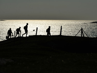 Silhouettes of people returning from Dogs Bay beach, in Ervallagh, during the COVID-19 lockdown. 
Next Monday there will be another slight e...