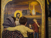 A child points a child in a religious painting with motives of the Chernobyl disaster in a holy mass during the remembrance of the 35th anni...