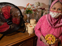Indonesian women, clad in masks and gloves due to the COVID-19 coronavirus pandemic, prepare traditional biscuits on 26 April 2021 in Depok,...