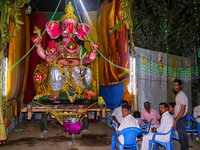 Large clay idol of Lord Ganesha (Lord Ganesh) at a pandal (temporary shrine) along the roadside during the festival of Ganesh Chaturthi in K...