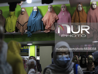 An Indonesian Muslim woman wearing face mask looking for headscarves at a hijab shop in Bogor on April 26, 2021, during the Muslim holy fast...