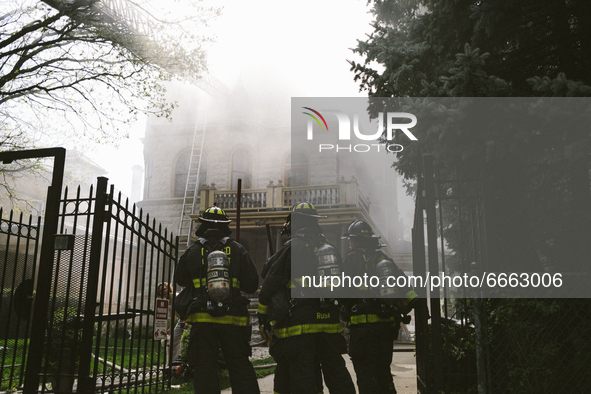 Firefighters watch as the home billows smoke from the fire of the Historic House In Palmer Square, Chicago, USA, on April 27, 2021. A house...