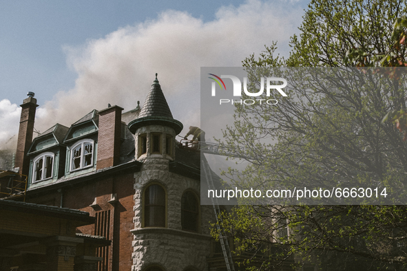 Fire fighters climb a ladder to gain access to the home's rooftop of the Historic House In Palmer Square, Chicago, USA, on April 27, 2021. A...