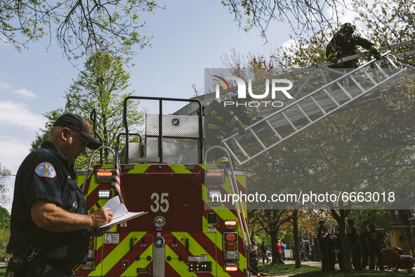 Fire fighters unhook a ladder from the fire truck of the Historic House In Palmer Square, Chicago, USA, on April 27, 2021. A house fire brok...