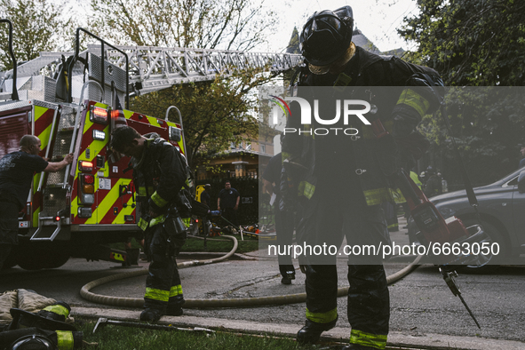 The firefighters drop their gear on the ground after battling the fire from the Historic House In Palmer Square, Chicago, USA, on April 27,...