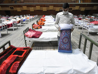 A worker sets up beds at a makeshift Covid-19 hospital cum containment in Srinagar, Indian Administered Kashmir on 27 April 2021. Authoritie...