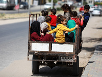 A Palestinian family rides in the back of a tuktuk in a street in Gaza City, on April 28, 2021.  (