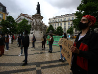 Students wearing protective masks and holding signs alluding to the university crisis march through the different streets of Lisbon. April 2...