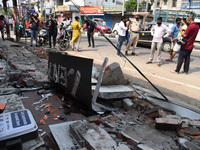 People look on at debris after a portion of a building were damaged due to earthquake at Bhetapara in Guwahati, Assam, India on April 28, 20...