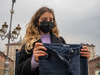  A woman holds a jeans during a flashmob to protest against gender violence in  Piazza Castello, Turin, Italy, on April 28, 2021. The event...