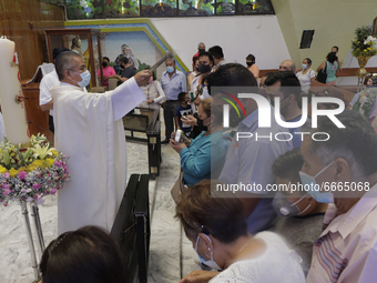 A priest blesses attendees inside the Parish of St. Jude Thaddeus the Apostle located in Mexico City, Mexico, on April 28, 2021 during the C...
