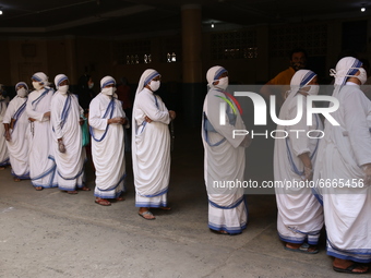 Missionary of Charity Nuns wearing mask shows their voter id card as they queued in front of a polling station, during 8th phase of West Ben...
