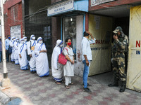 Sisters of Missionaries of Charity wait in queue in front of a polling station to cast their vote during the final phase of West Bengal asse...