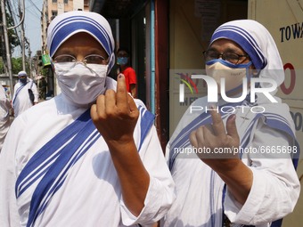  Nuns of Missionaries of Charity  wearing mask shows her inked finger after casting her vote  at a polling station during  8th phase of West...