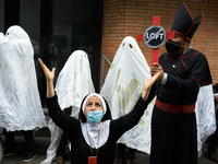 Ghosts culture workers stand with actors playing a bishop and a nun with a cross. Disguised culture workers (actors, live artists, dancers,...