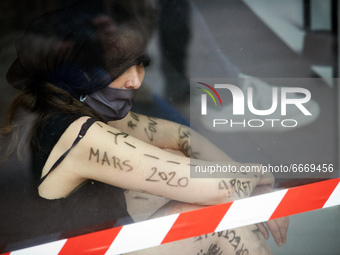 A dancer stands in a shop window and has written on her arm 'All stopped in March 2020'. . Disguised culture workers (actors, live artists,...