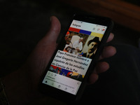 A person observes a publication on his mobile phone about the Venezuelan saint Jose Gregorio Hernandez. San Cristóbal, 30 April 2021. The Ca...