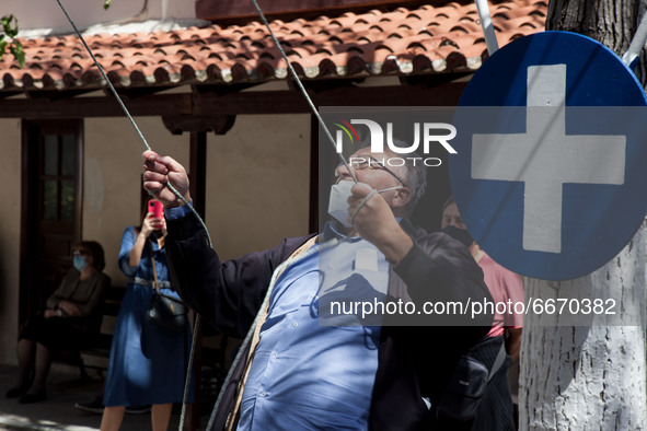A man rings the bell at the church of Agioi Anargyroi Holy Metohi Panagiou Tafou in Plaka, Athens, Greece, on April 30, 2021. 