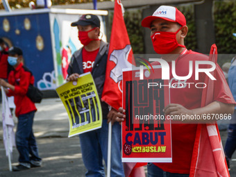Indonesian worker holds placard during May Day rally in Bandung, Indonesia on May, 01, 2021. Protesters across Indonesia have organized rall...