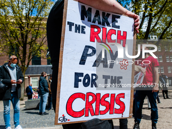 A man is holding a placard against rich people during the International Worker's Day demonstration held in Amsterdam, on May 1st, 2021. (